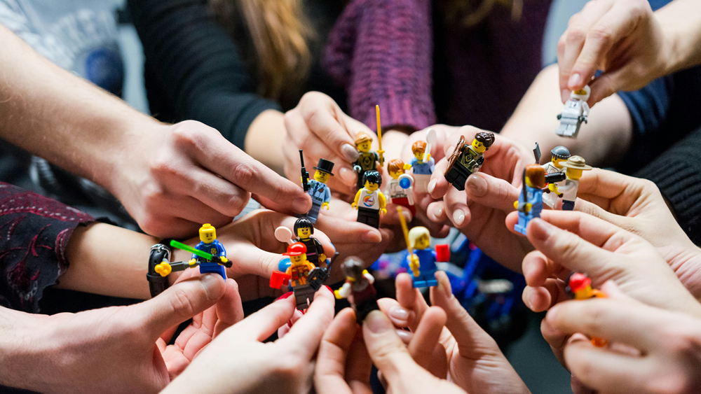 Group of people holding lego people.