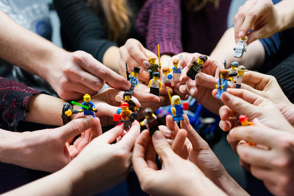 Group of people holding lego people.