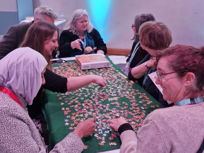 I group of people at Jisc's Digifest conference attempting a jigsaw puzzle