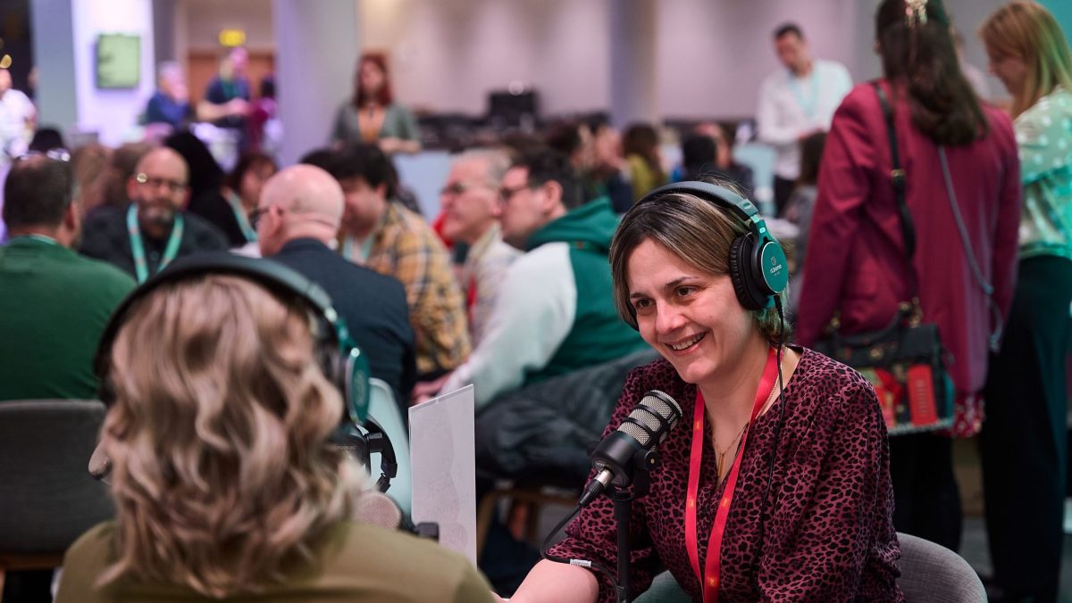 Two people recording a podcast on the Digifest Community Hub. Both are wearing headsets and speaking into microphones