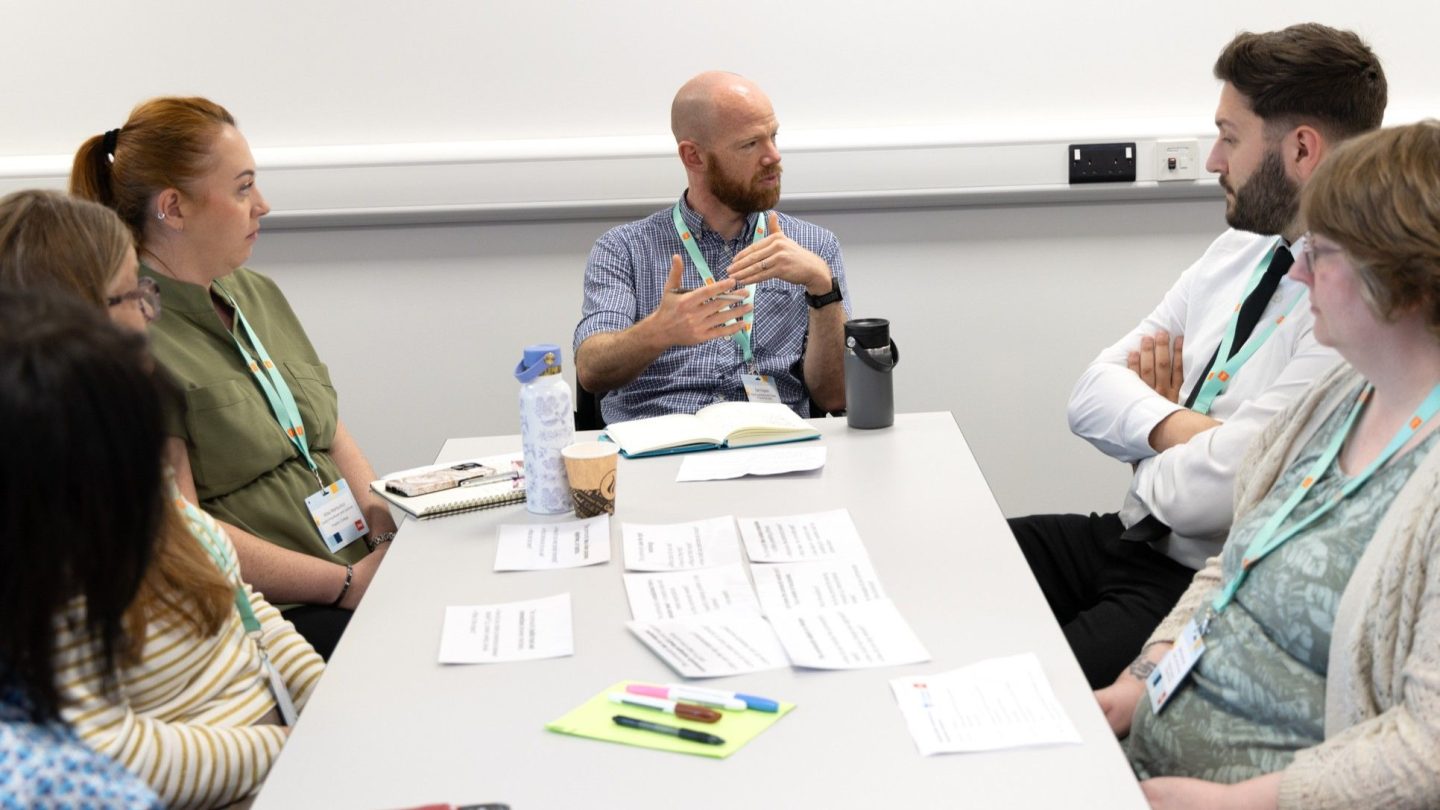 A groups of four women and two men discussing the recipe for success cards at the Powered by People event, 30 June 2026